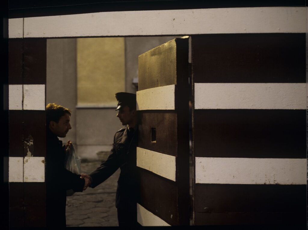 Karol (Zbigniew Zamachowski) saying hello to a prison guard by the prison gate.