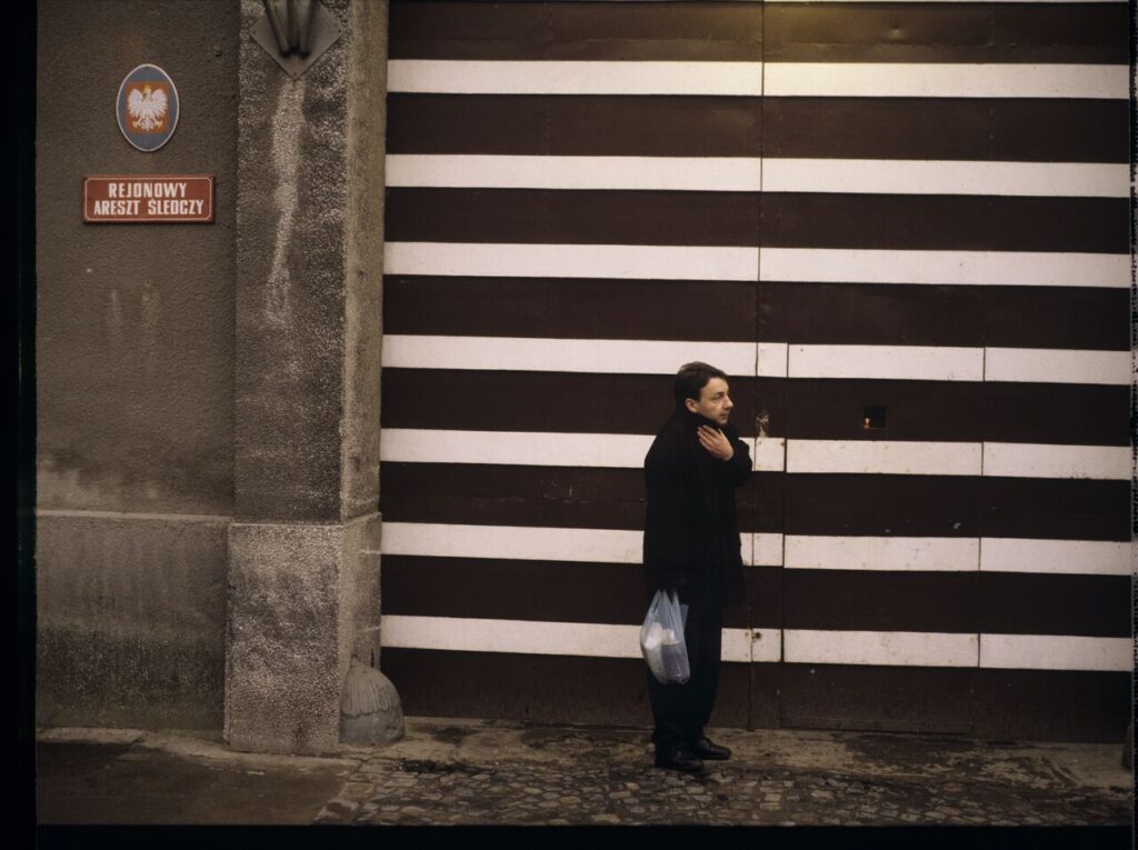 Karol (Zbigniew Zamachowski) by the prison gate.