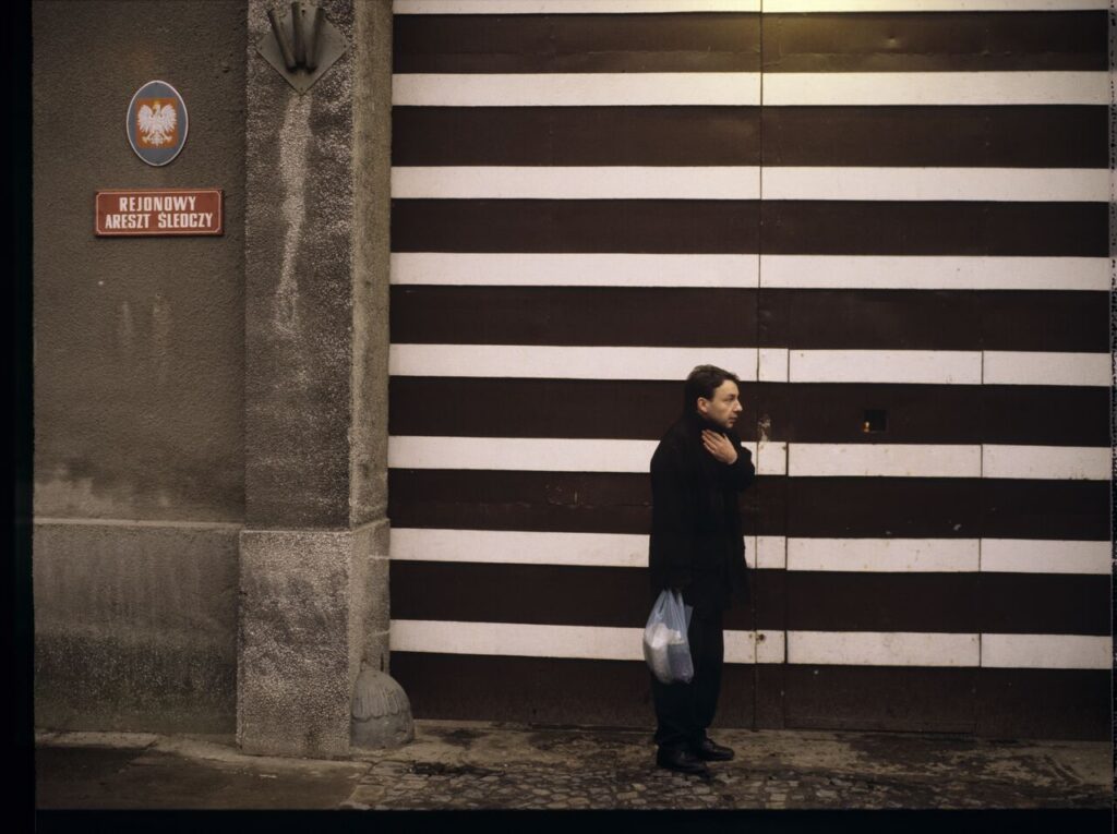 Karol (Zbigniew Zamachowski) by the prison gate.