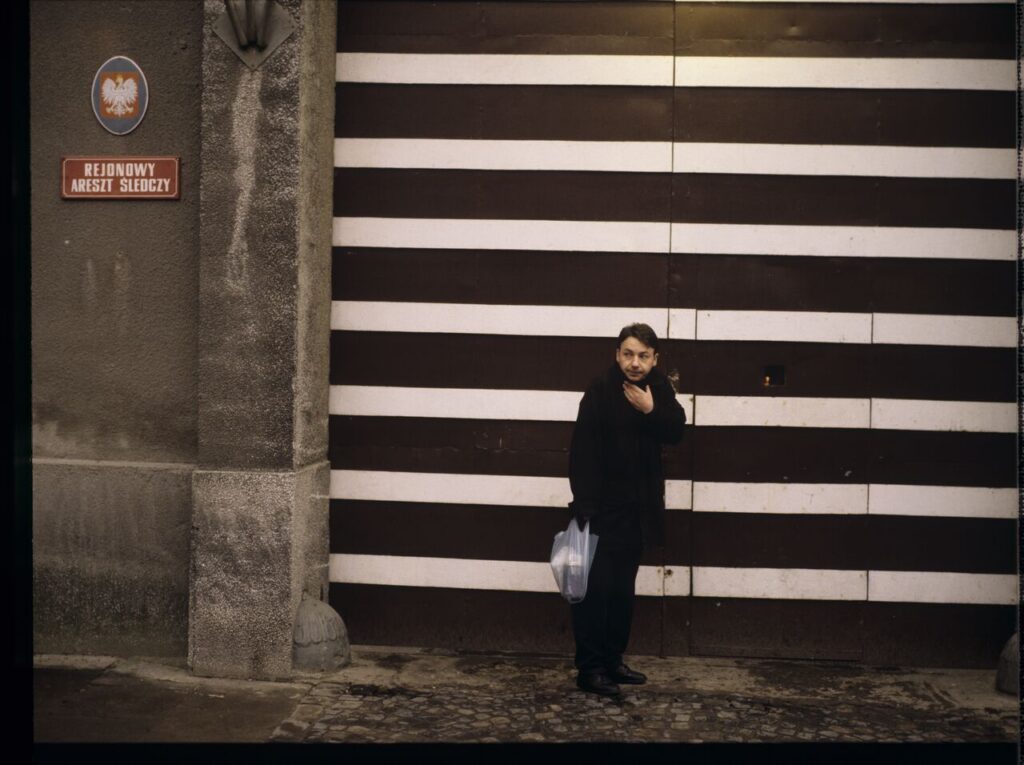 Karol (Zbigniew Zamachowski) by the prison gate.