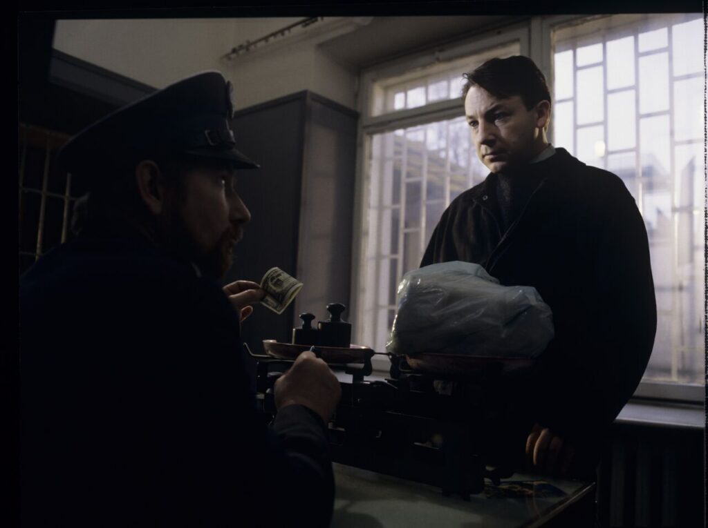 Karol (Zbigniew Zamachowski) is giving a prison guard a package for his ex-wife Dominique.