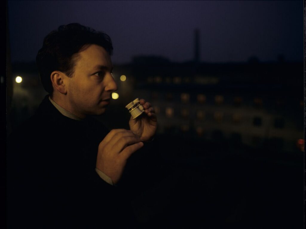 Karol (Z. Zamachowski) observes the silhouette of his ex-wife Dominique through binoculars, visible in the prison window.