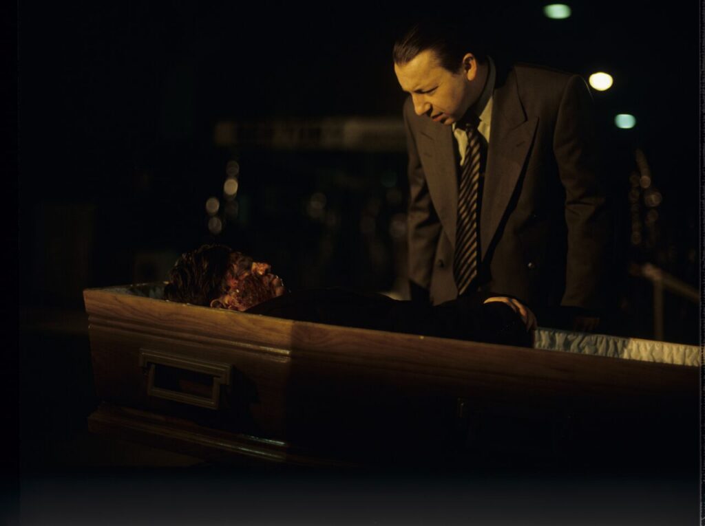 Karol (Zbigniew Zamachowski) looks at a "purchased" corpse that is supposed to make his faked death credible.