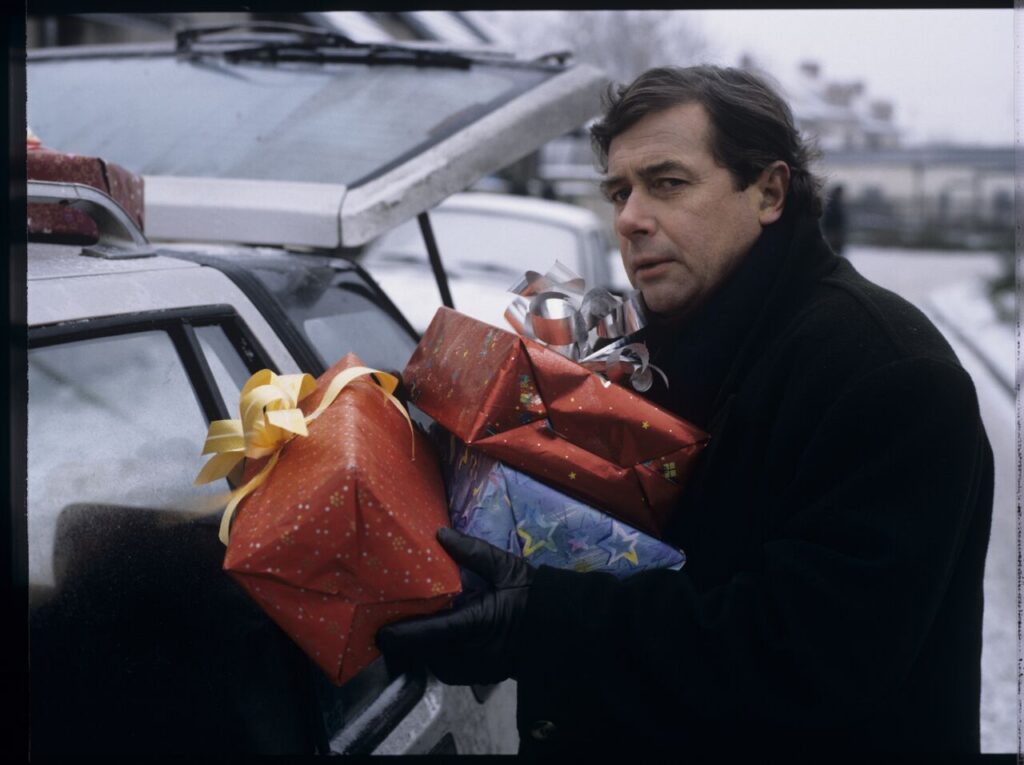 Santa Claus (Janusz Gajos) in front of his house with Christmas presents for his family.