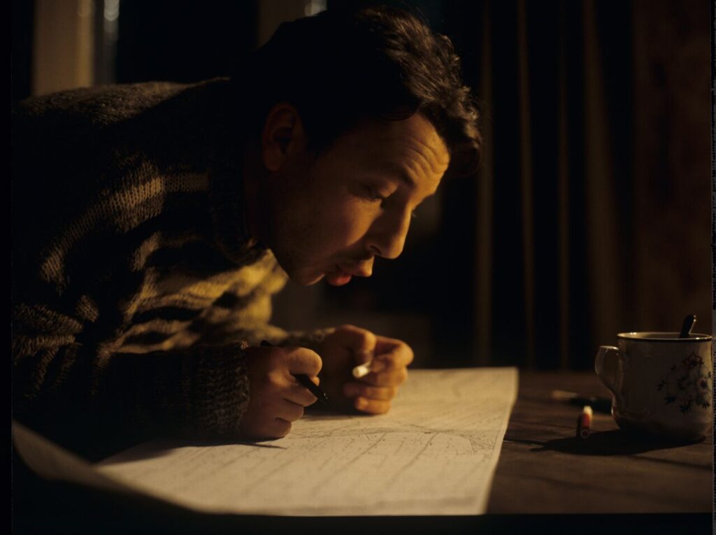 Karol (Zbigniew Zamachowski) looking at pland of lands he purchased.