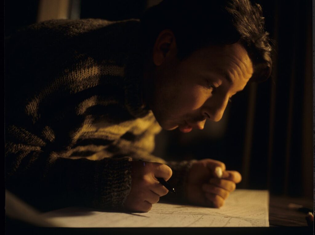 Karol (Zbigniew Zamachowski) looking at pland of lands he purchased.