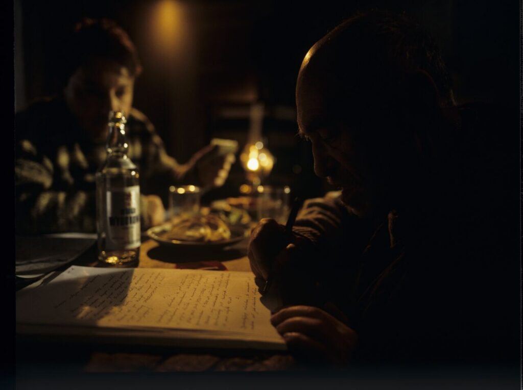 An old farmer (Jerzy Nowak) signs the documents for the sale of land to Karol (Zbigniew Zamachowski).