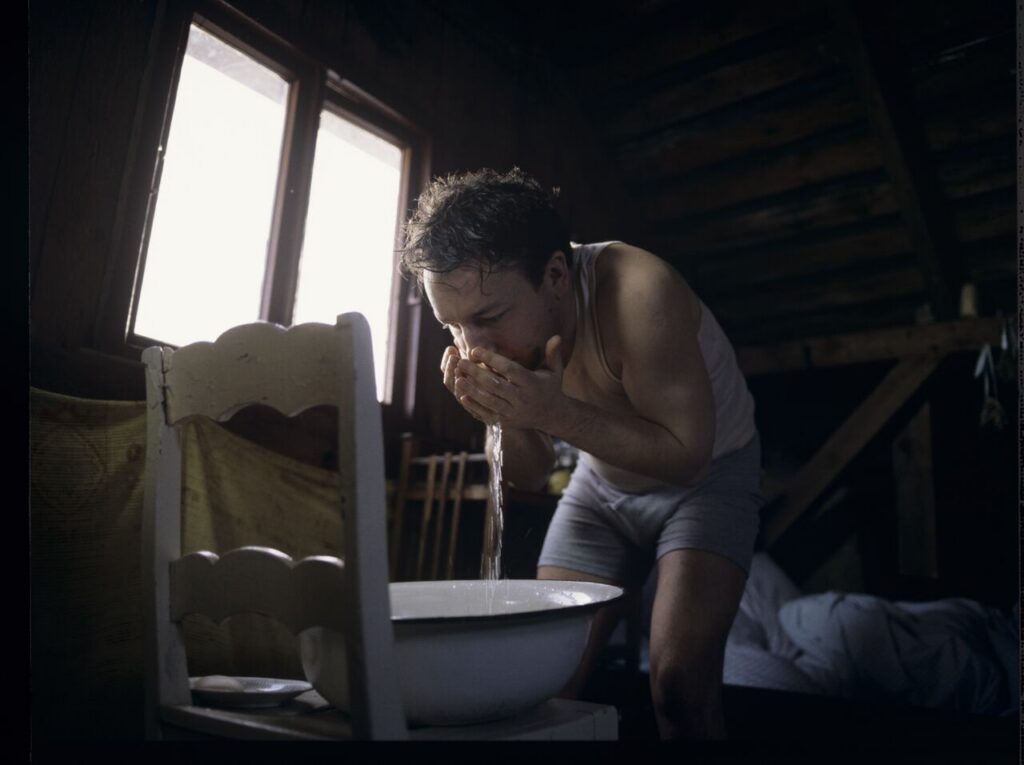 Karol (Zbigniew Zamachowski) wakes up in the farmer's house the day after a successful land purchase transaction.