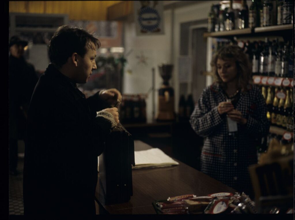 Karol (Zbigniew Zamachowski) buys alcohol to help him persuade the host to sell the land.