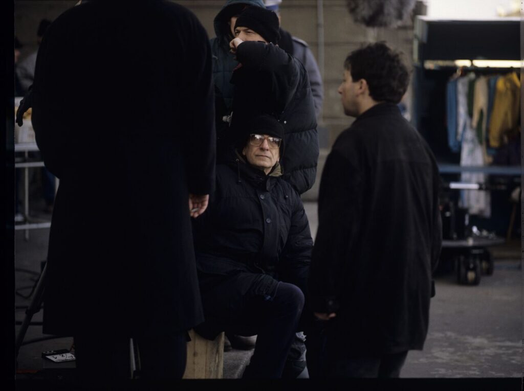 Krzysztof Kieślowski (director) and Zbigniew Zamachowski (playing the role of Karol) surrounded by the crew on the set.