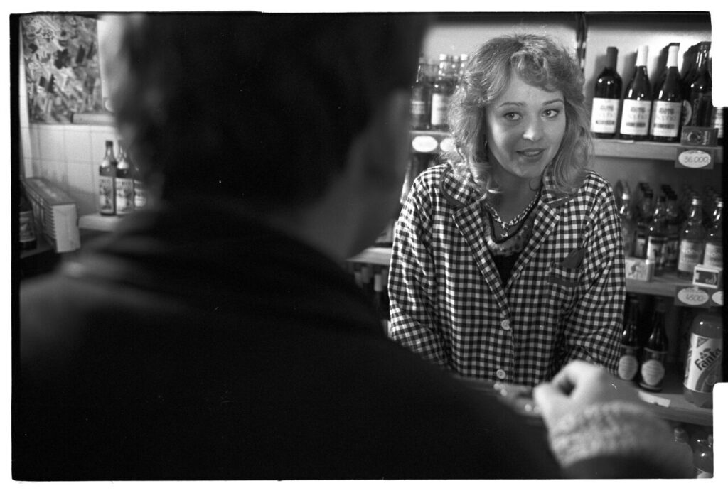 Karol (Zbigniew Zamachowski) buys alcohol to help him persuade the host to sell the land.