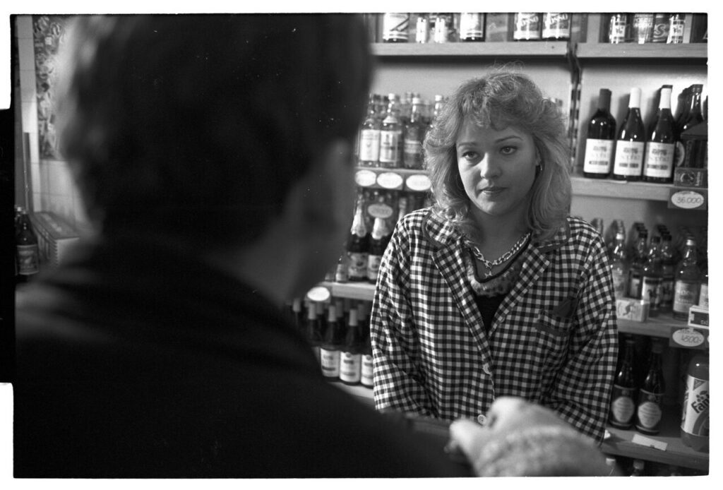 Karol (Zbigniew Zamachowski) buys alcohol to help him persuade the host to sell the land.