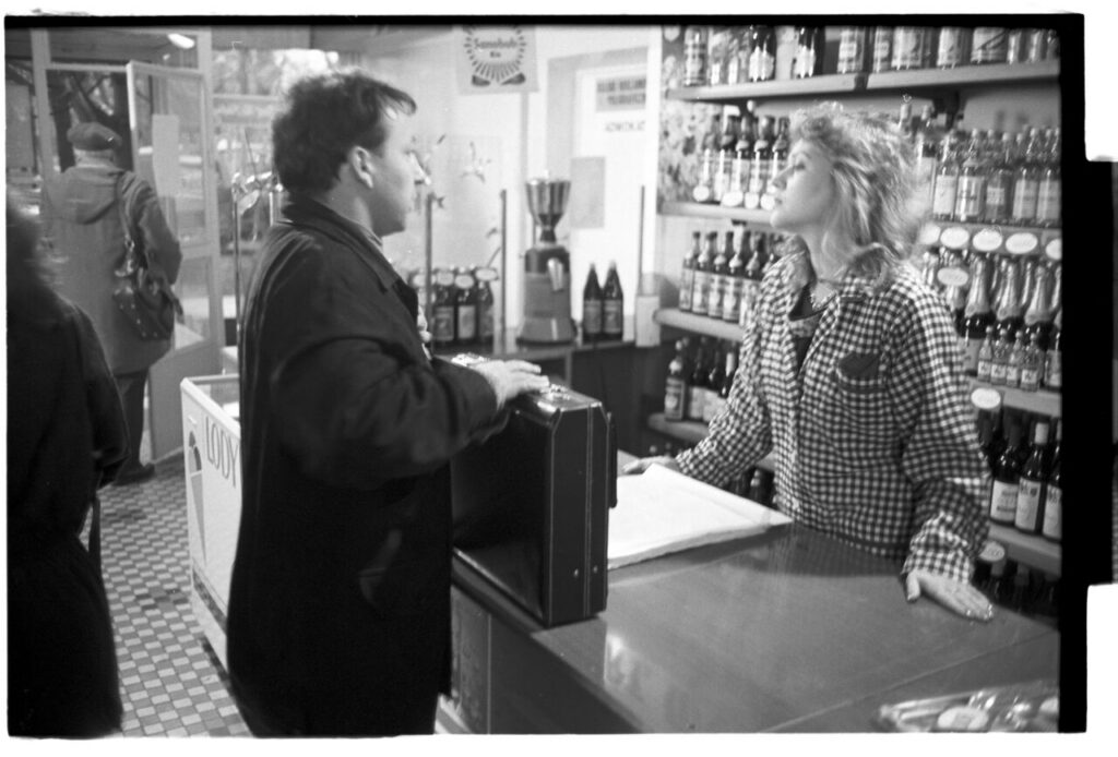 Karol (Zbigniew Zamachowski) buys alcohol to help him persuade the host to sell the land.