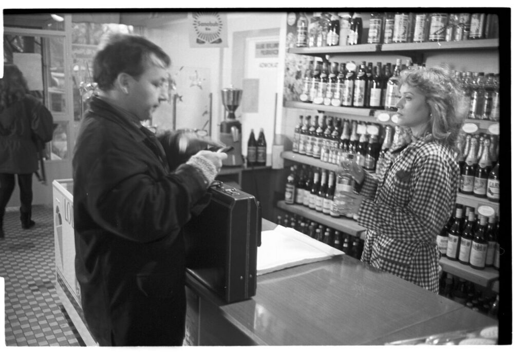 Karol (Zbigniew Zamachowski) buys alcohol to help him persuade the host to sell the land.