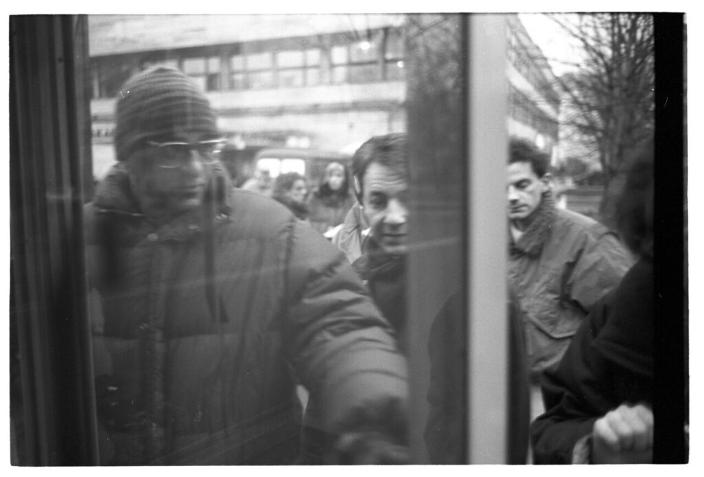 Krzysztof Kieślowski (director) and Zbigniew Zamachowski (playing Karol) on set in front of a liquor store.