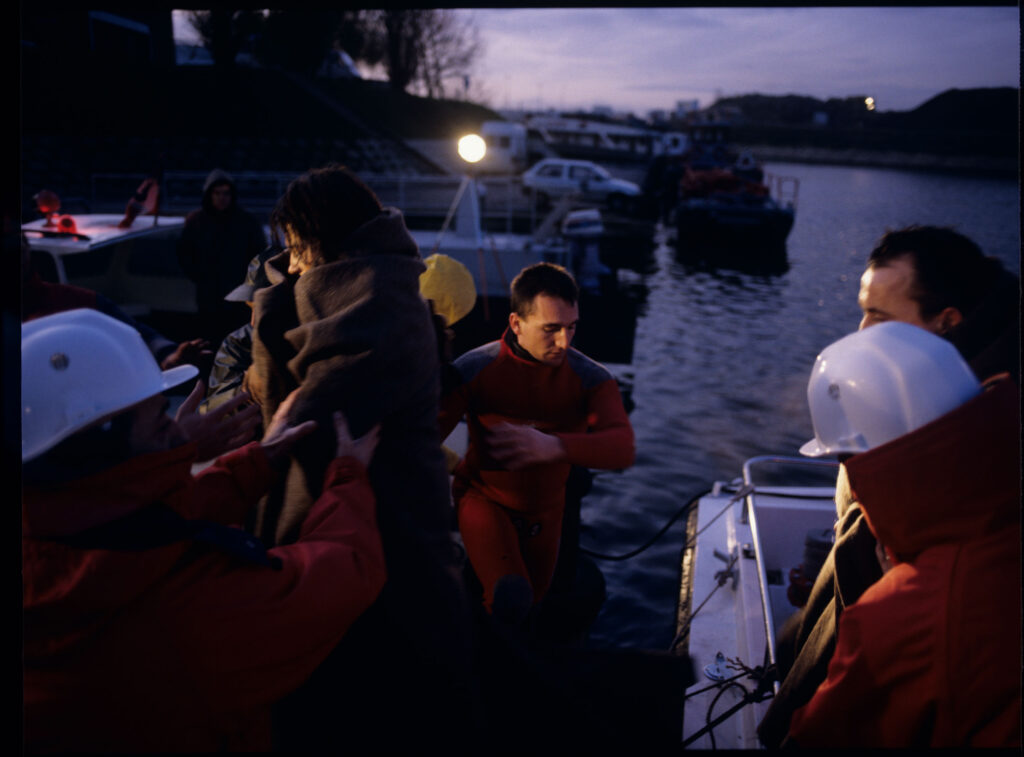 Scena zakończonej akcji ratowniczej po katastrofie promu. Valentine (Jacob) zostaje sprowadzona z łodzi ratunkowej.