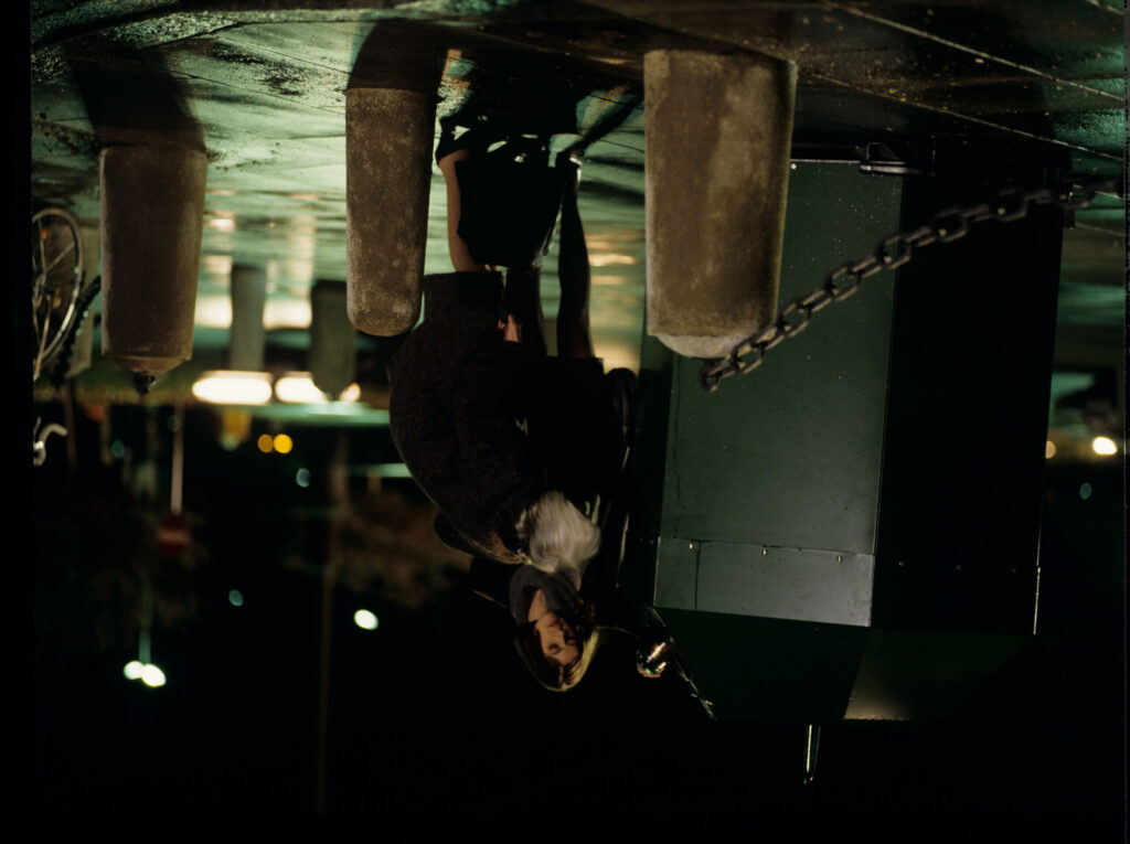 Valentina (Irène Jacob) helps an elderly woman throw a bottle into the recycling bin.