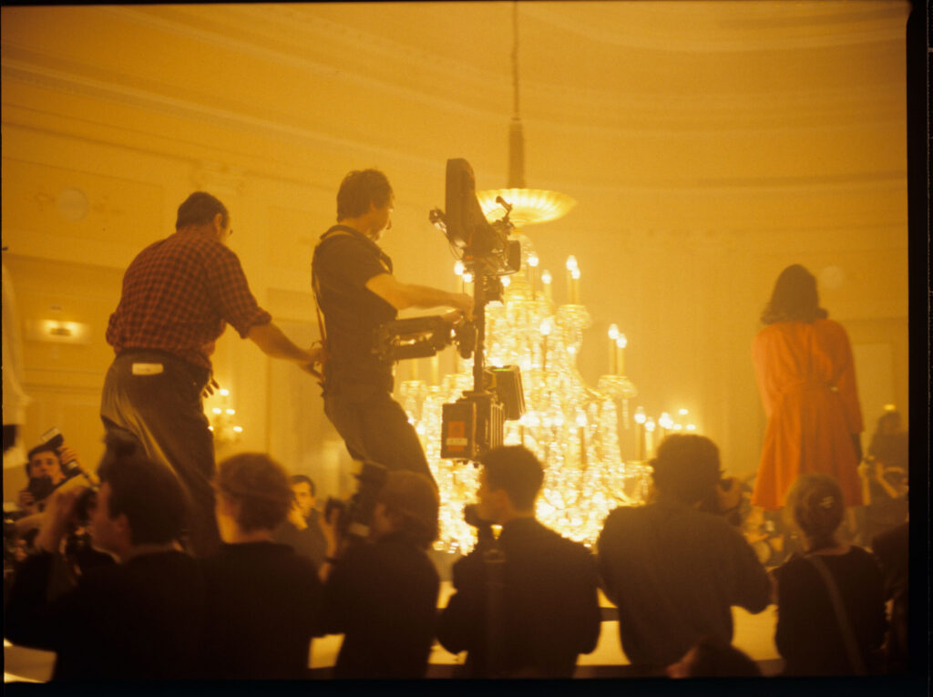 Filming a fashion show scene at a theater.