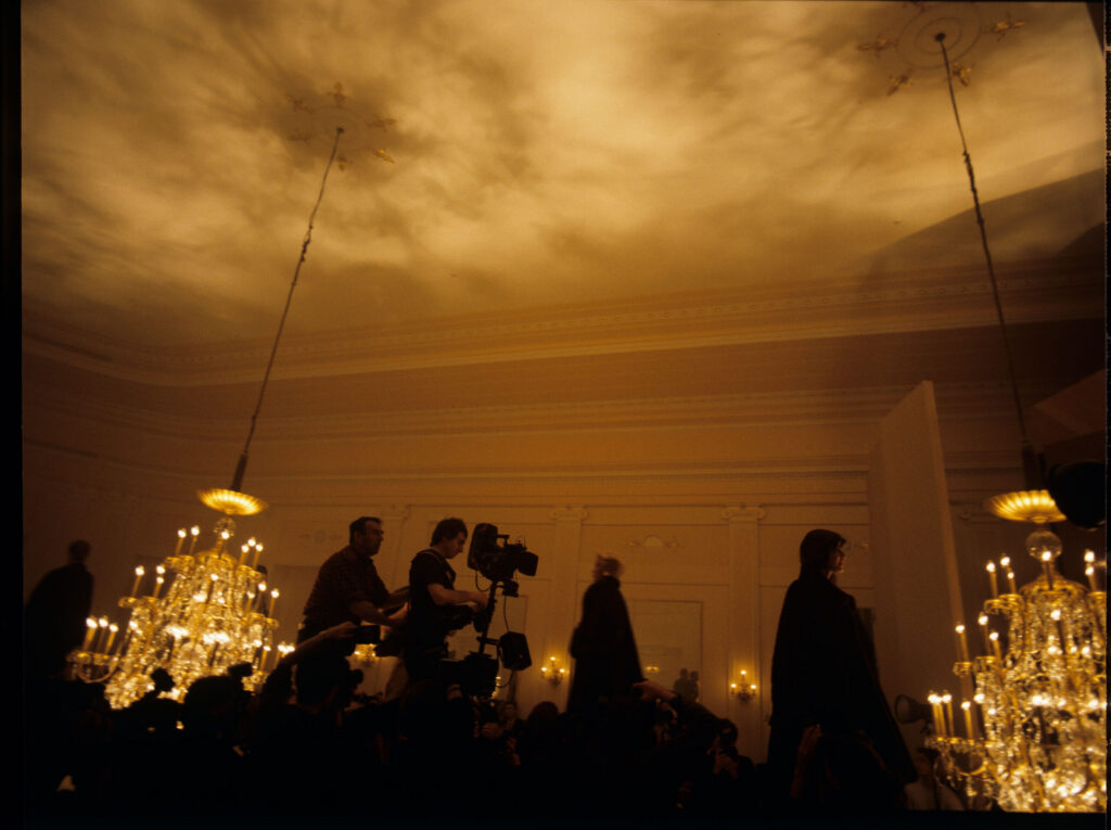 Filming a fashion show scene at a theater.