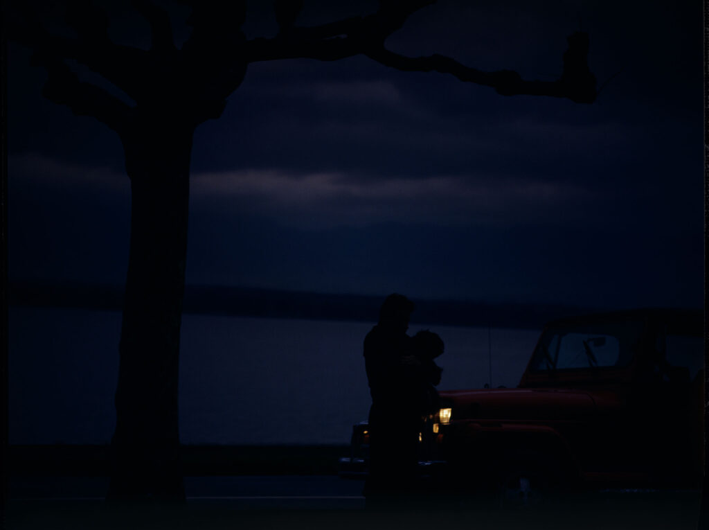 Auguste (Jean-Pierre Lorit) z psem przy samochodzie.