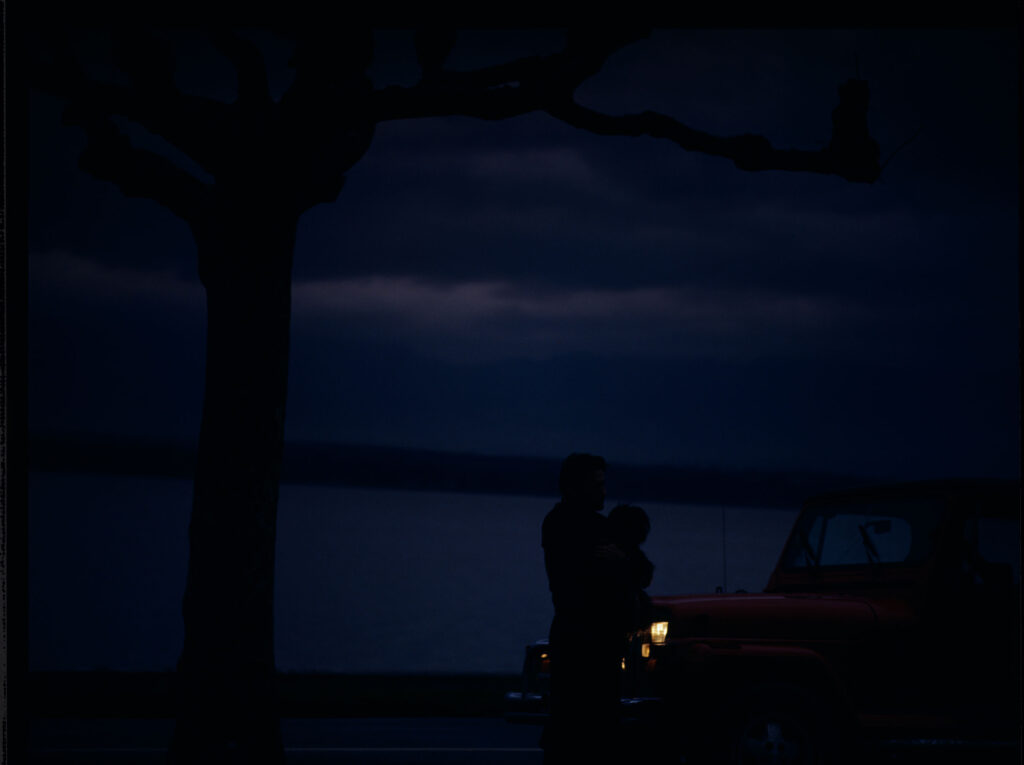 Auguste (Jean-Pierre Lorit) z psem przy samochodzie.