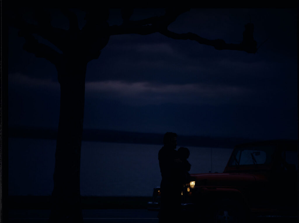 Auguste (Jean-Pierre Lorit) with his dog by the car.