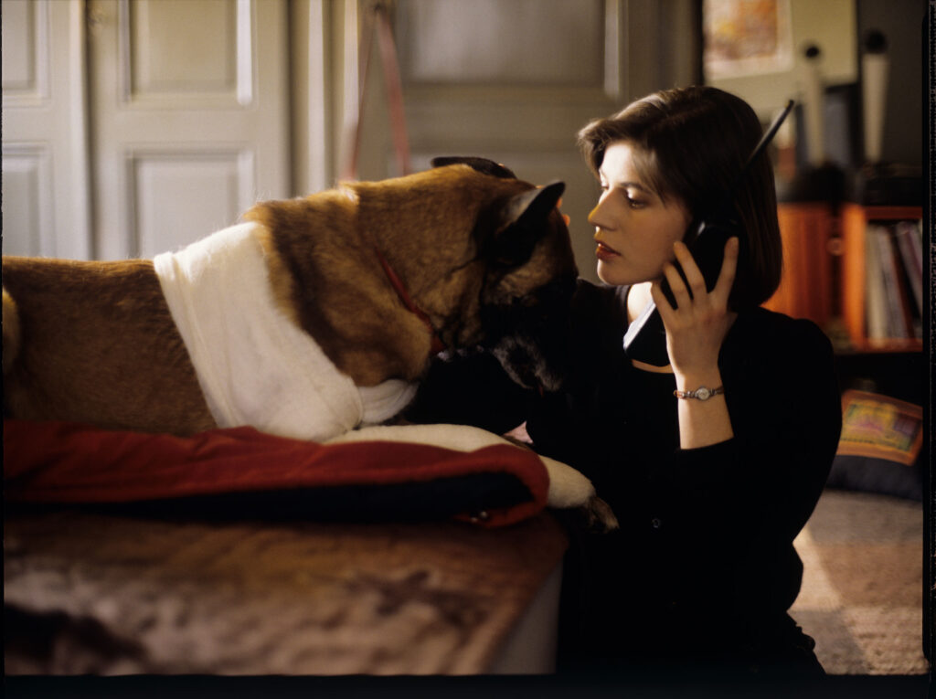 Valentine (Irène Jacob) z psem w swoim mieszkaniu rozmawia przez telefon z przebywającym w Londynie narzeczonym Michelem.