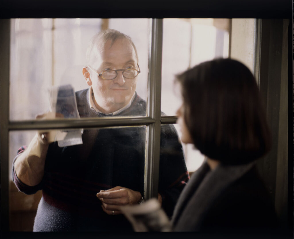 Valentine (Irène Jacob) talks to a neighbor (Jean Schlegel) who brought money from a judge for treating a dog.