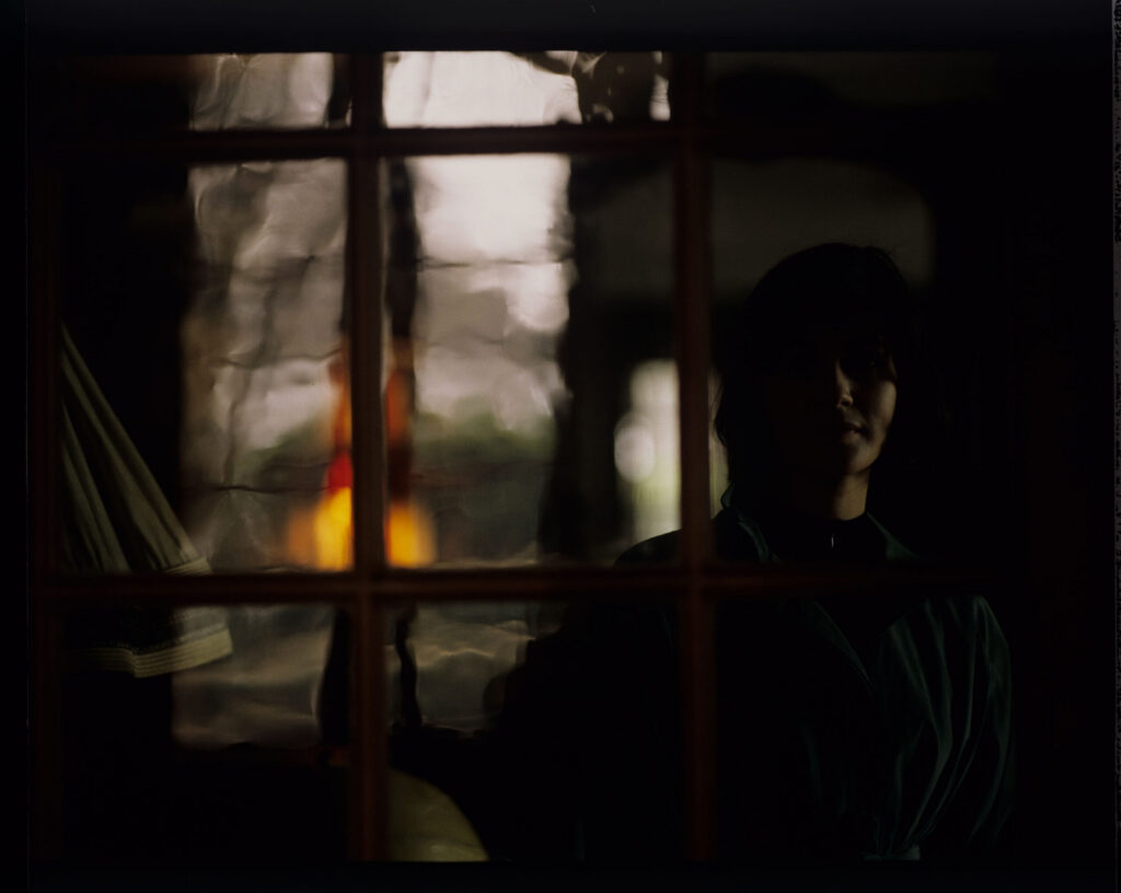 Valentine (Irène Jacob) looks out the window of the judge's apartment.