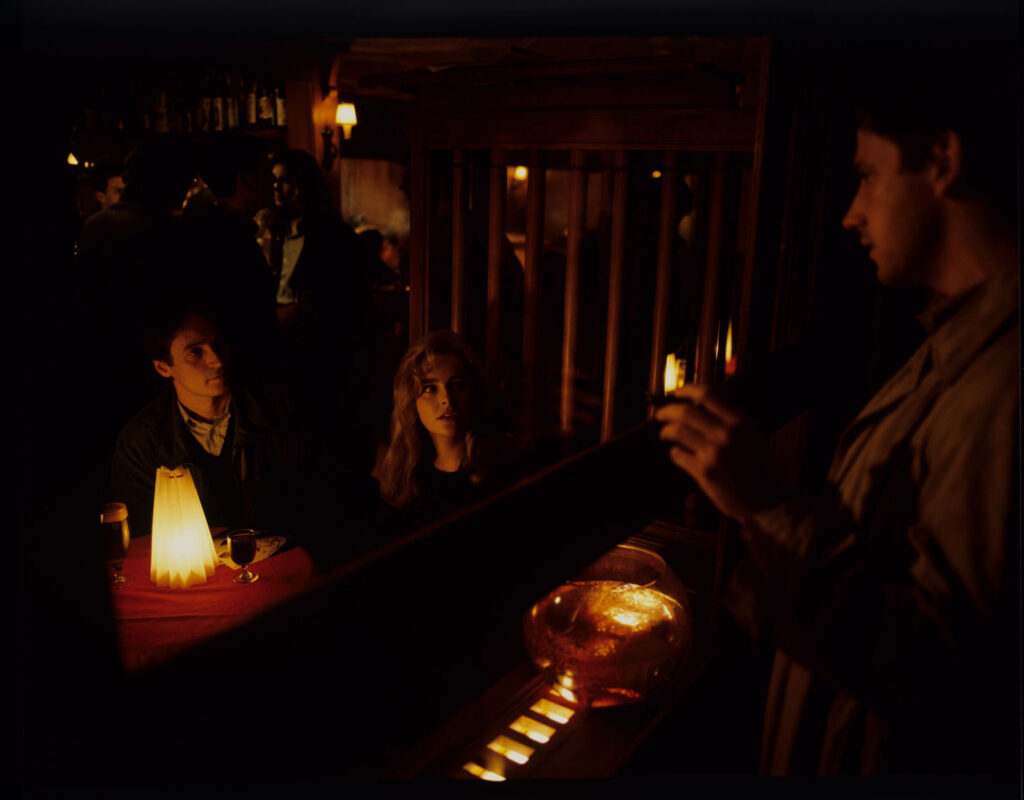 Auguste (Jean-Pierre Lorit) sees his partner Karin (Frederique Feder) with another man through the window of a café.