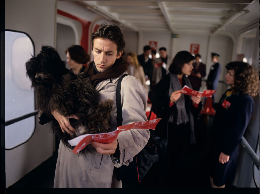 Valentine (Jacob) is looking for his place on the ferry to England. Bruner (Lorit) is in the foreground.