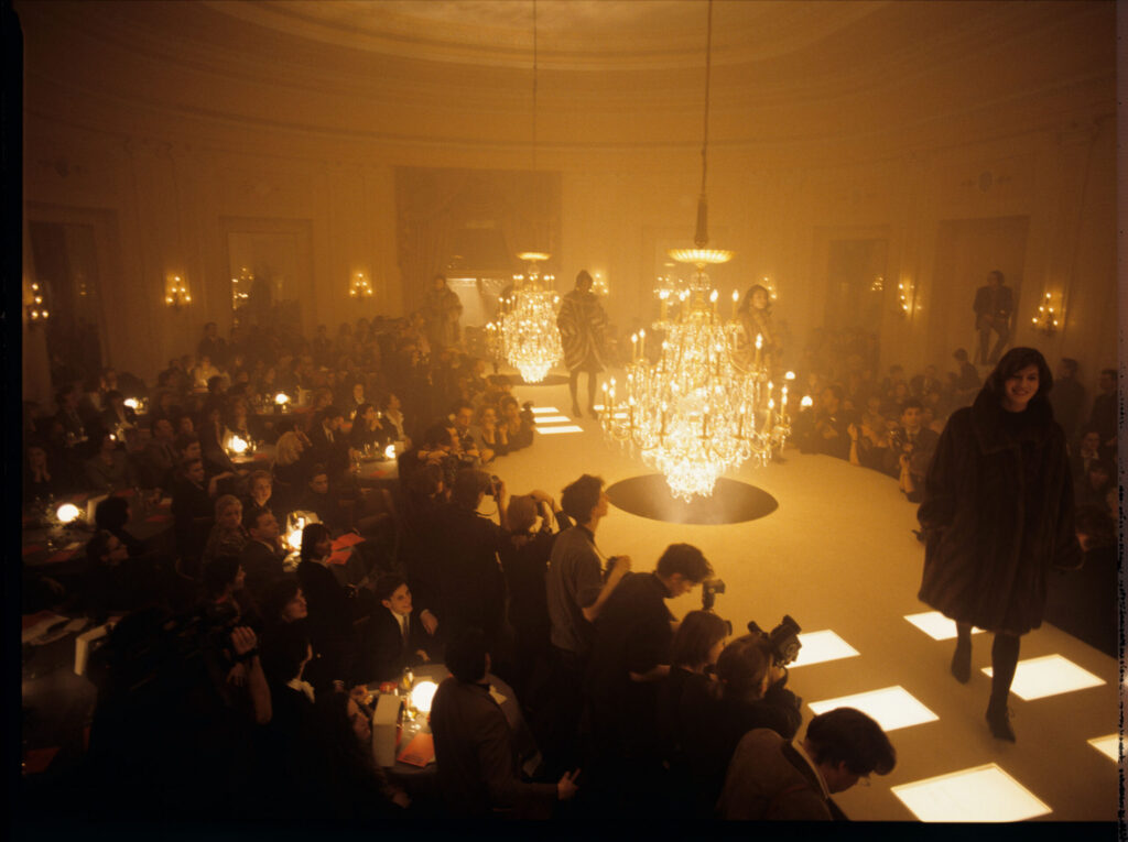 A fashion show featuring Valentine (Irène Jacob). The main frame is filled with reporters.