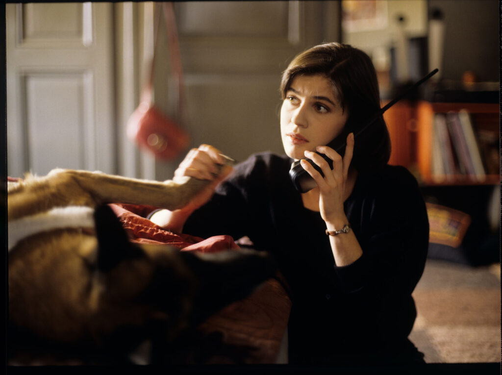 Valentine (Irène Jacob) z psem w swoim mieszkaniu rozmawia przez telefon z przebywającym w Londynie narzeczonym Michelem.