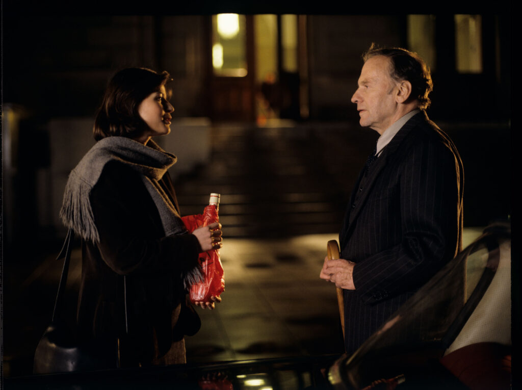 Emerytowany sędzia Joseph Kern (Jean-Louis Trintignant) obdarowuje Valentine (Irène Jacob) butelką calvadosu.