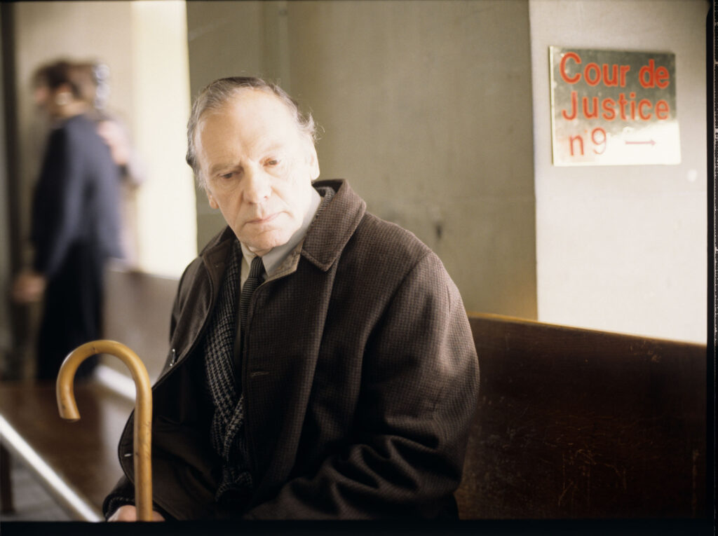 Emerytowany sędzia Kern (Trintignant) oskarżony o podsłuchiwanie telefonicznych rozmów czeka na rozprawę w sądzie w Genewie.
