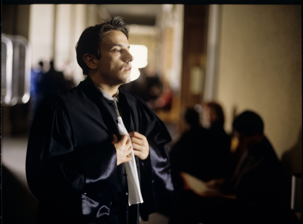 Auguste (Jean-Pierre Lorit) in the courthouse corridor.