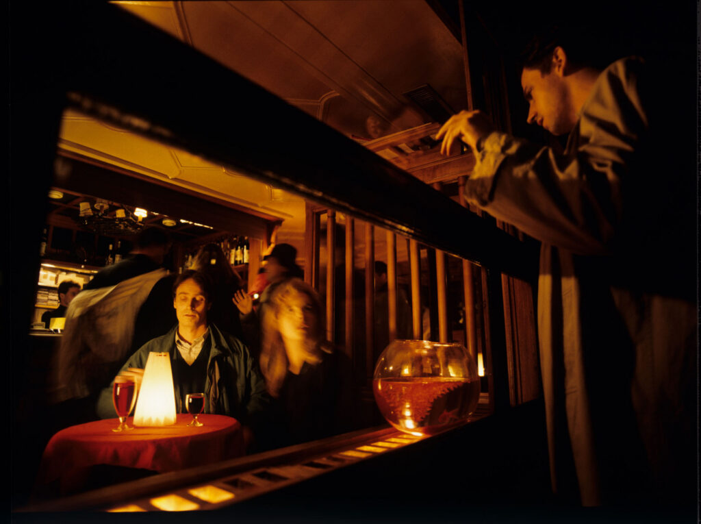 Auguste (Jean-Pierre Lorit) sees his partner Karin (Frederique Feder) with another man through the window of a café.