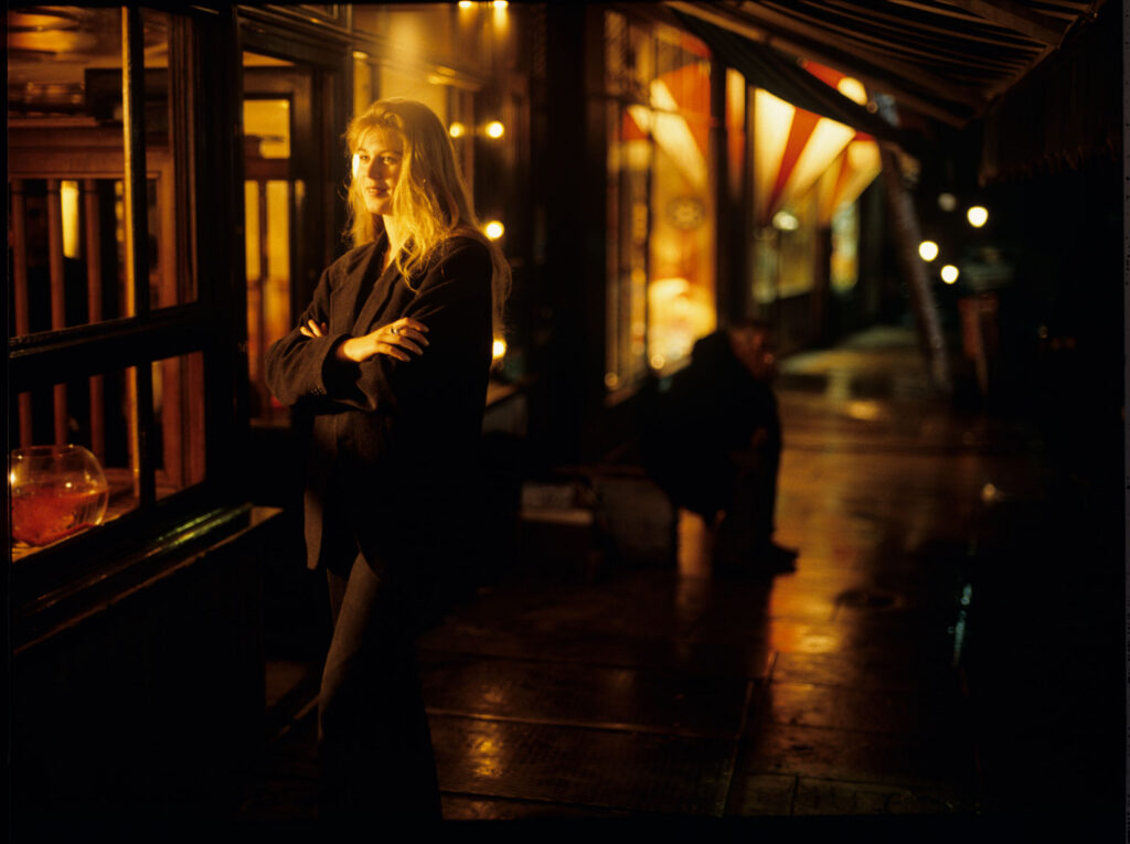 Auguste's partner, Karin (Feder), runs out of the café to meet Auguste, who has noticed her through the window.