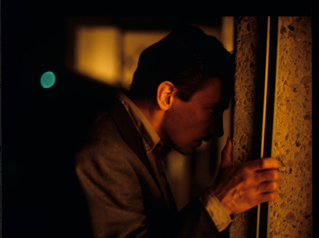 Auguste (Jean-Pierre Lorit) watching his partner with another man.