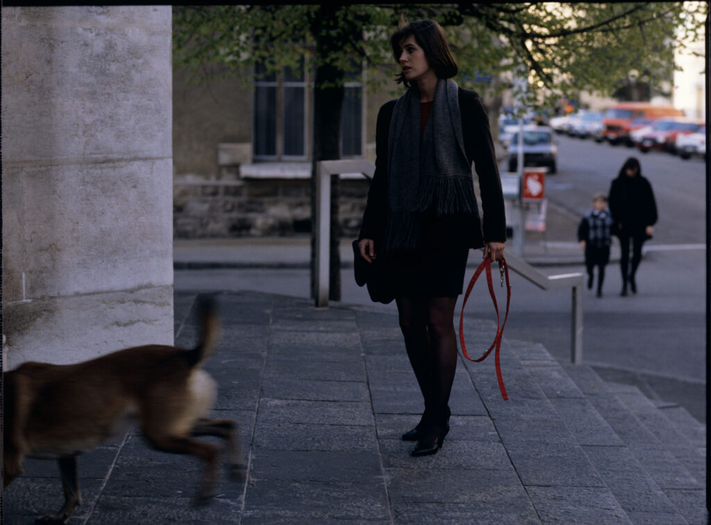 Valentine (Irène Jacob) walking her dog.