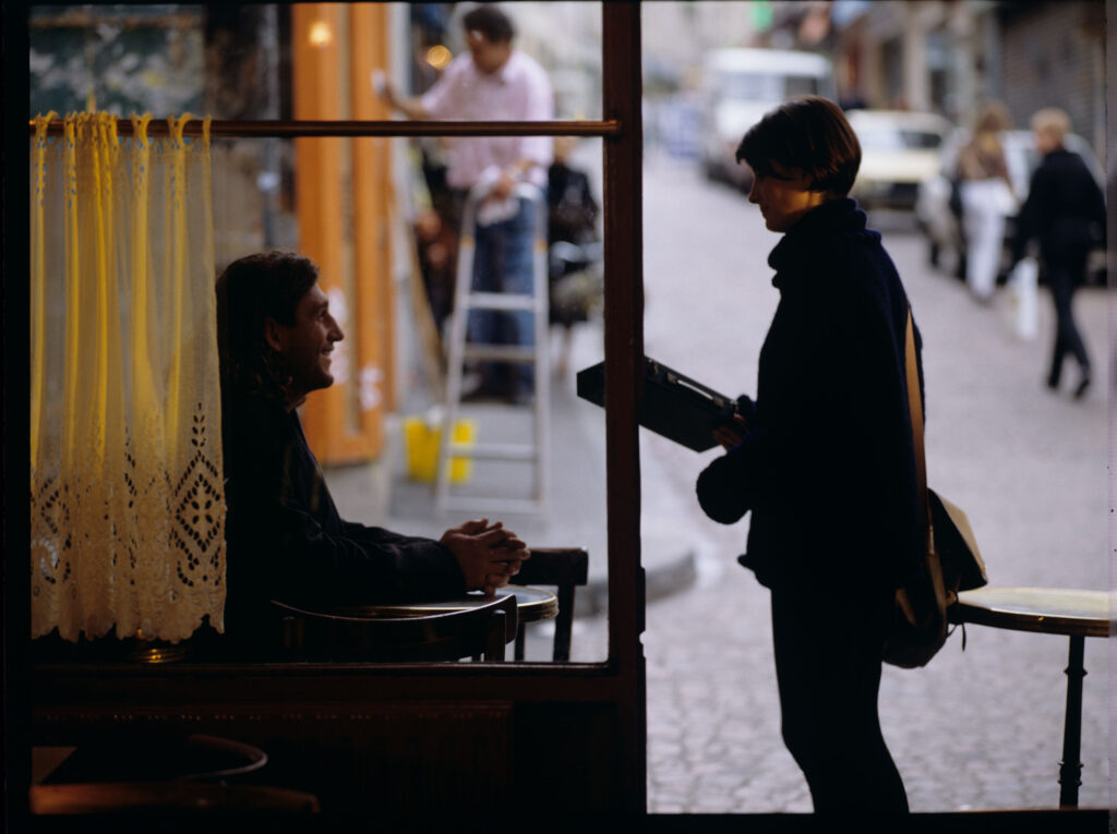 Julie (Juliette Binoche) przed kawiarnią, w której codziennie spędza czas.