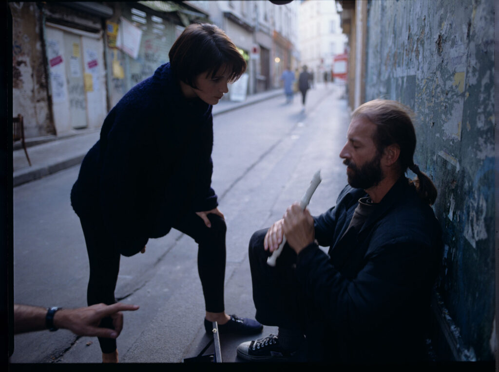 Julie (Binoche) talks to a street flautist (played by Jacek Ostaszewski - Polish musician).
