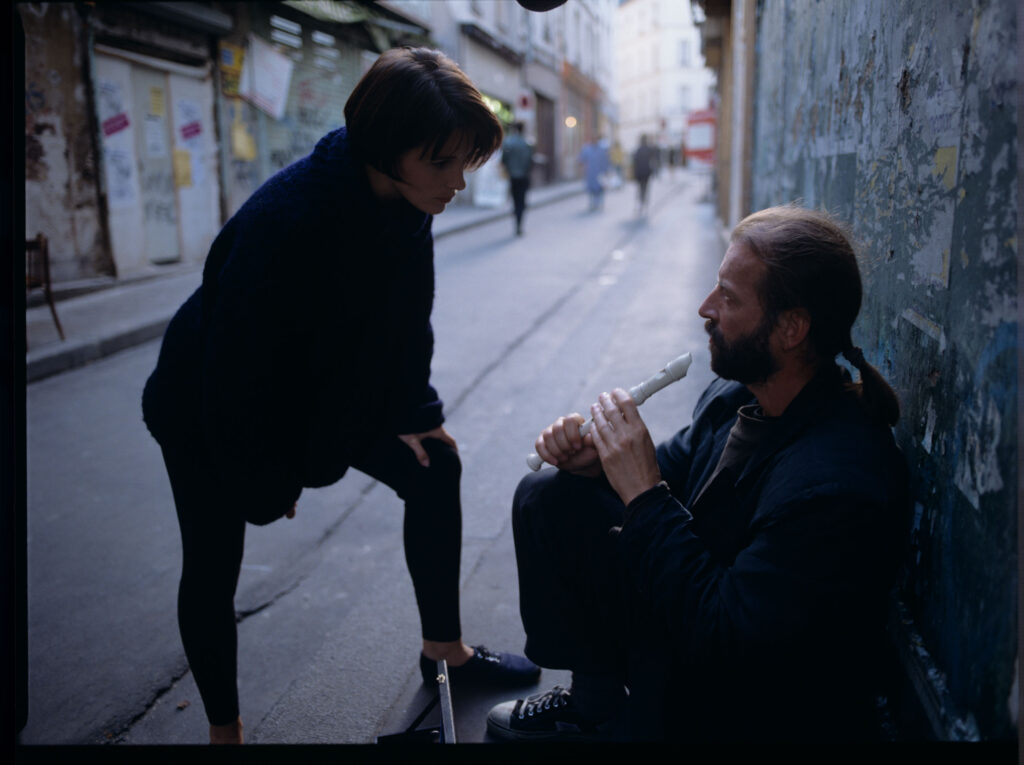 Julie (Juliette Binoche) rozmawia z ulicznym flecistą (w tej roli Jacek Ostaszewski - polski kompozytor i muzyk jazzowy).