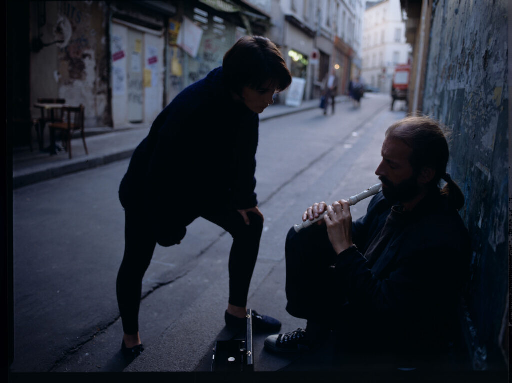 Julie (Juliette Binoche) rozmawia z ulicznym flecistą (w tej roli Jacek Ostaszewski - polski kompozytor i muzyk jazzowy).