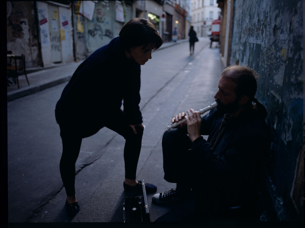 Julie (Juliette Binoche) rozmawia z ulicznym flecistą (w tej roli Jacek Ostaszewski - polski kompozytor i muzyk jazzowy).