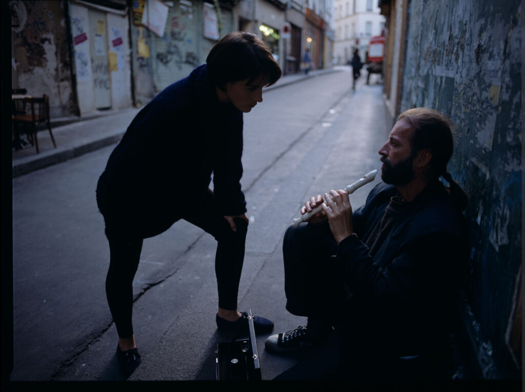 Julie (Juliette Binoche) rozmawia z ulicznym flecistą (w tej roli Jacek Ostaszewski - polski kompozytor i muzyk jazzowy).