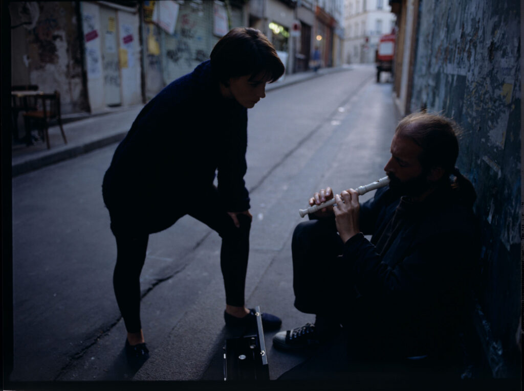 Julie (Juliette Binoche) talks to a street flautist (played by Jacek Ostaszewski - Polish composer and jazz musician).