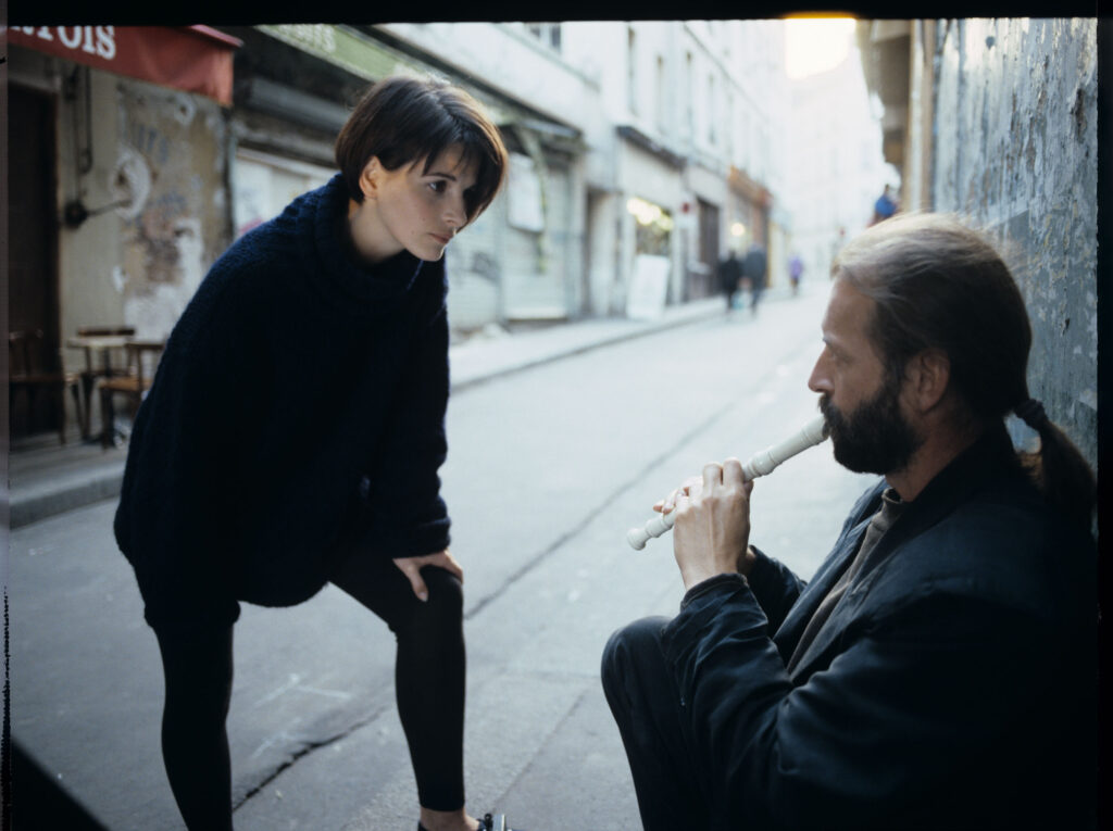Julie (Juliette Binoche) rozmawia z ulicznym flecistą (w tej roli Jacek Ostaszewski - polski kompozytor i muzyk jazzowy).