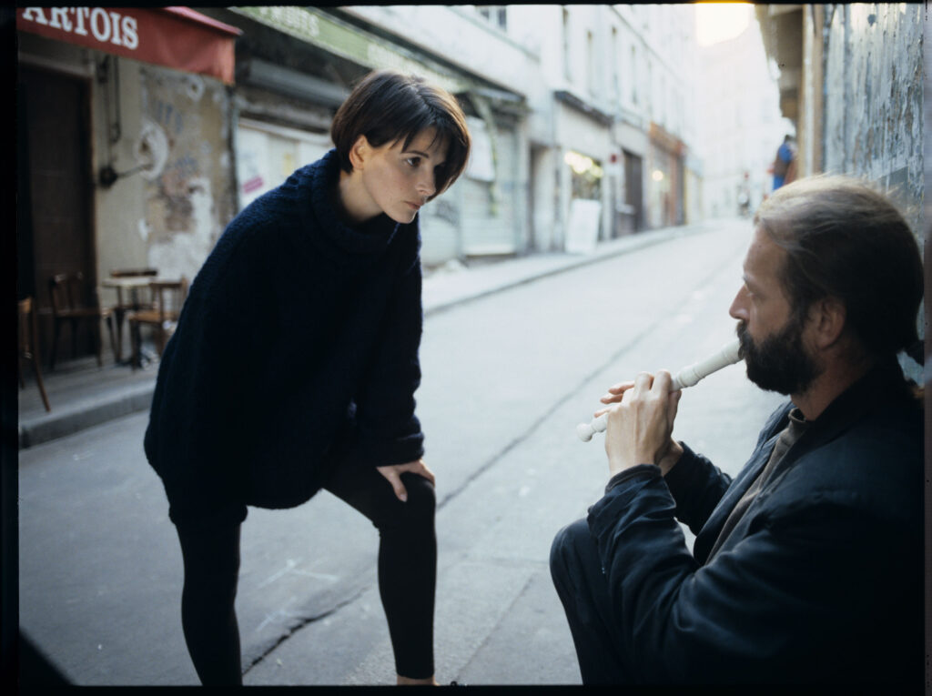 Julie (Juliette Binoche) rozmawia z ulicznym flecistą (w tej roli Jacek Ostaszewski - polski kompozytor i muzyk jazzowy).
