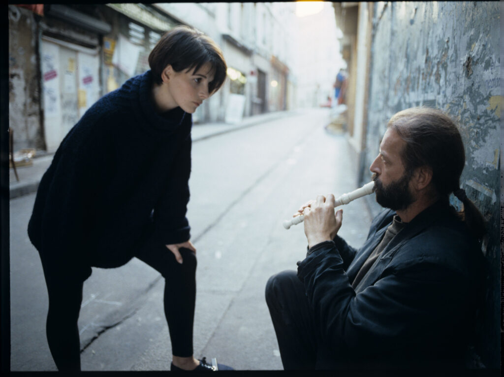 Julie (Juliette Binoche) rozmawia z ulicznym flecistą (w tej roli Jacek Ostaszewski - polski kompozytor i muzyk jazzowy).